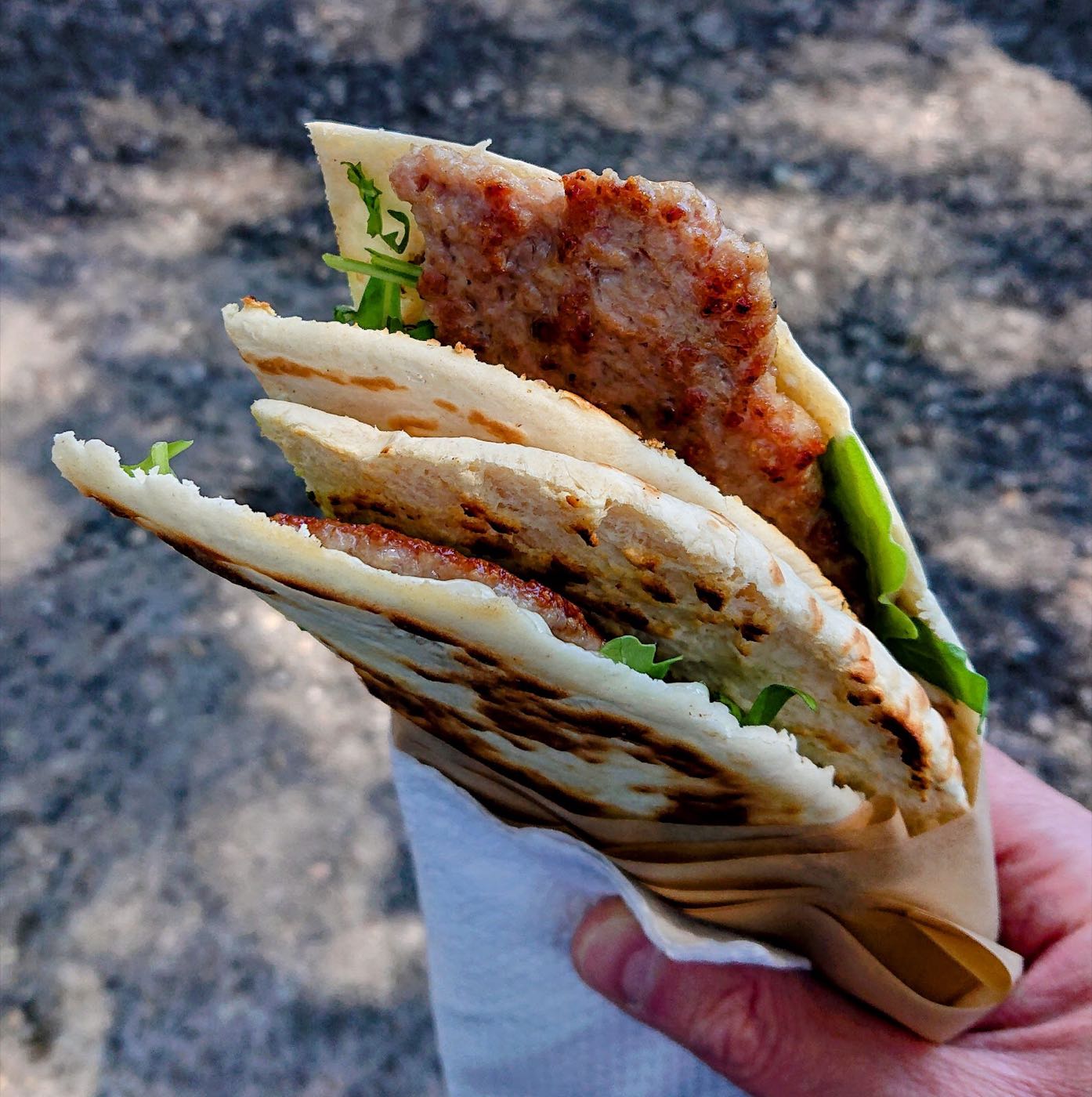 Piadina con salsiccia e rucola, appena fatta al chiosco