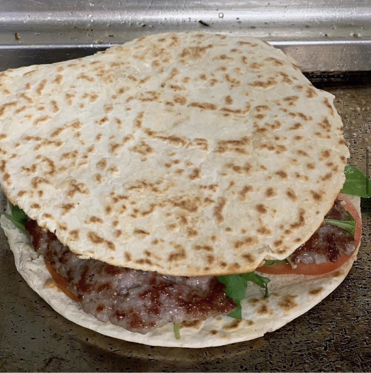 Piadina con salsiccia e pomodoro sulla piastra